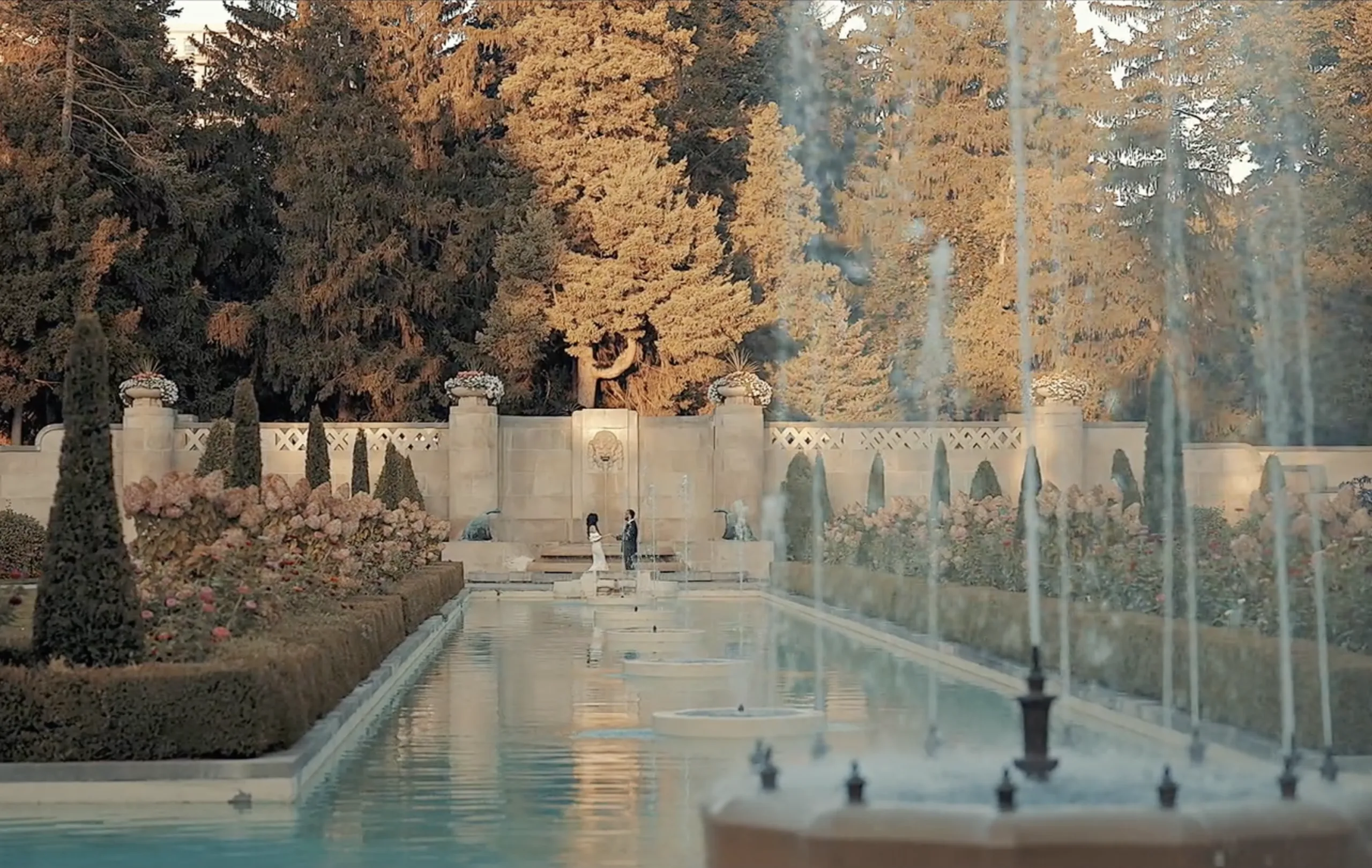 A couple at Parkwood Estate in Oshawa, a heritage mansion with classic gardens and stepping-stone paths.
