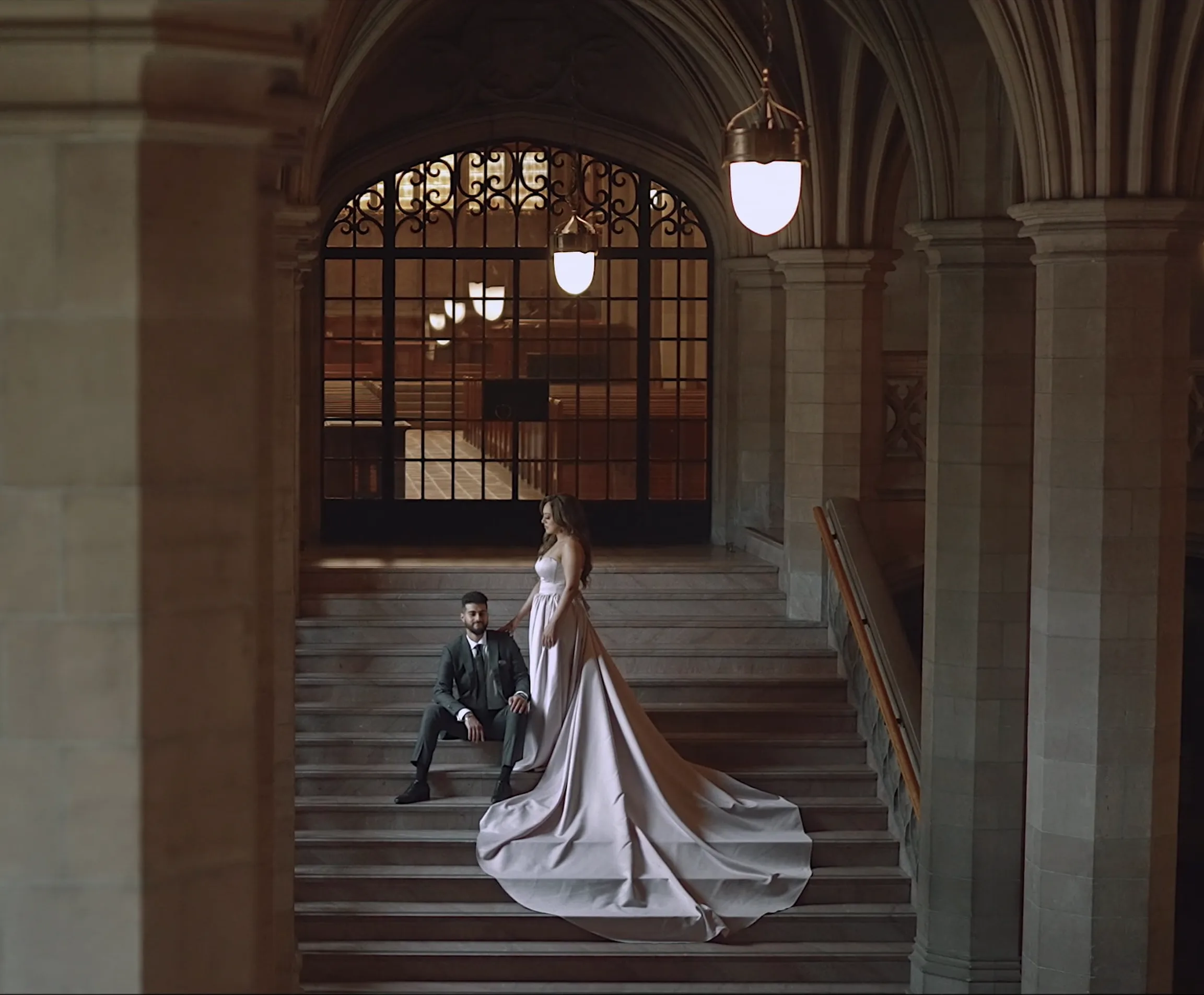 A couple walking through the Gothic stone arches and historic walkways of Knox College at the University of Toronto.