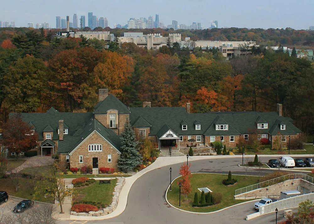 Historic stone manor exterior of The Glenerin Inn & Spa in a forest setting.