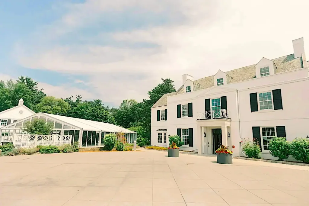 Historic 1930s white stone mansion and glass pavilion at Harding Waterfront Estate.